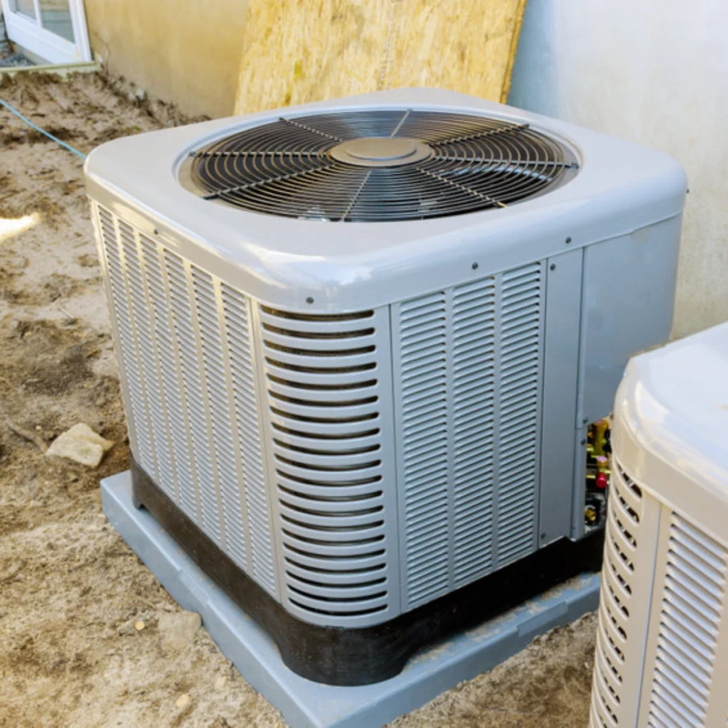 Grey outdoor air conditioning condenser unit on a concrete pad.